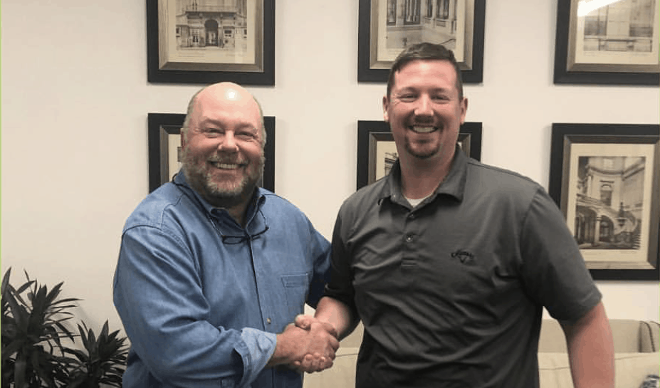 Pigtails & Crewcuts franchise owner Andrew McGehee shaking hands with CEO and President Wade Brannon