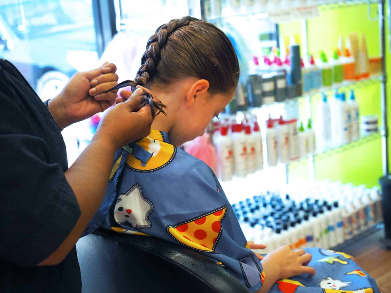 girl getting her hair braided in pigtails and crewcuts kids haircut franchise