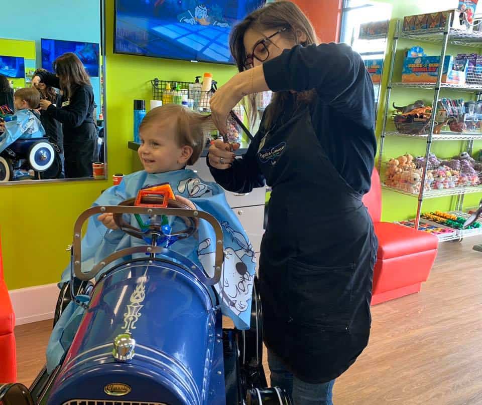 a child and stylist at Jennifer Tribble's Pigtails & Crewcuts children's hair salon