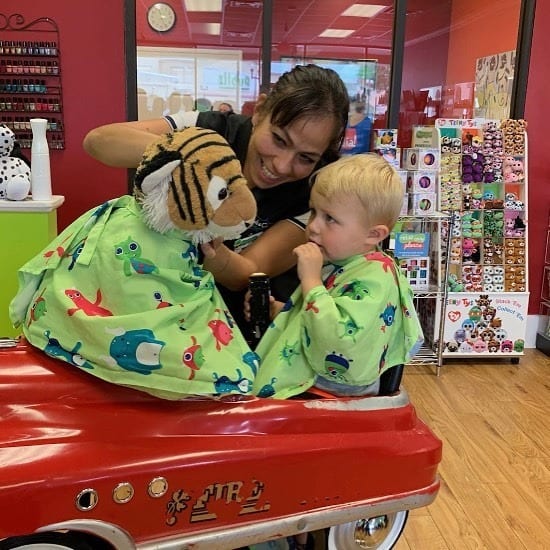 a stylist with a child at multi-unit franchisee Jennifer Tribble's salon