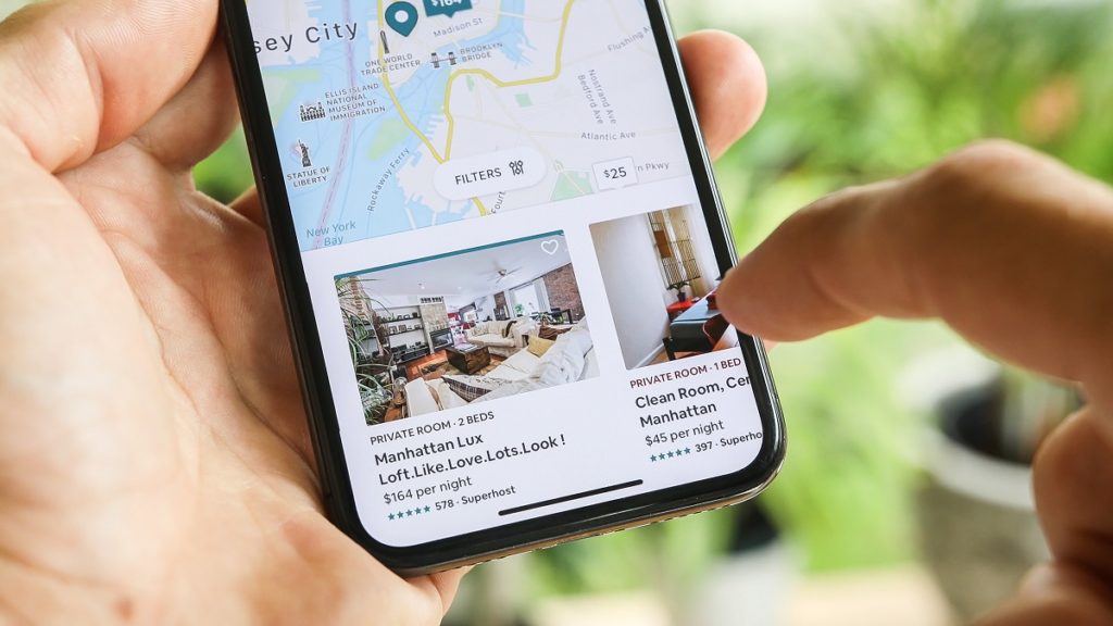 NEW YORK CITY, NY – December 1, 2019: Woman trying to book home apartment room in New York City using Airbnb app